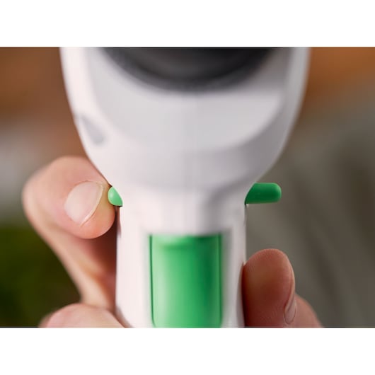 Close-up photo of BLACKDECKER REVDD12C white and green tool handle with trigger buttons.
