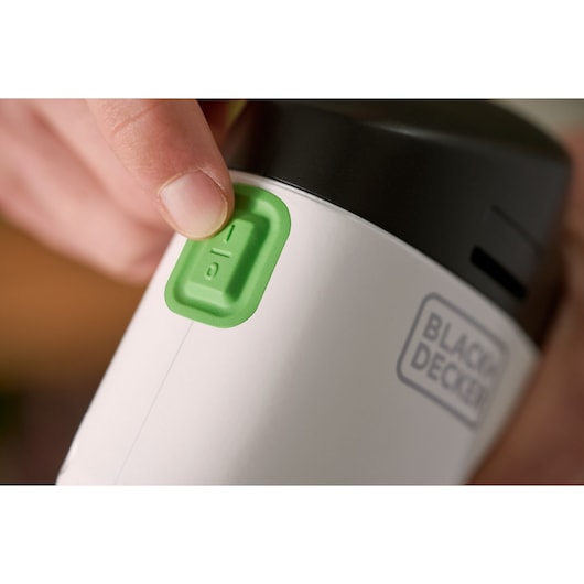 Close-up photo of BLACK+DECKER REVDS12C device with a green power button and a visible brand logo.