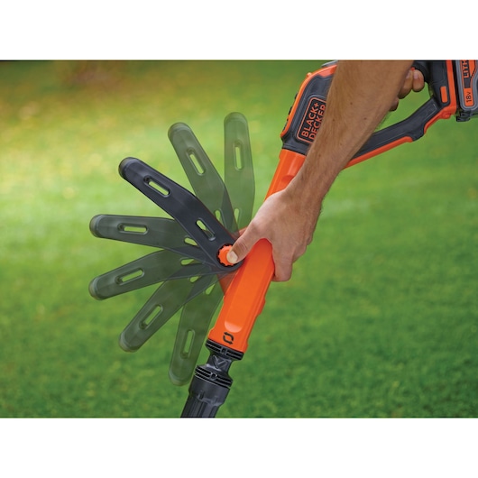 BLACK+DECKER STC1820EPC grass trimmer handle being adjusted outdoors, close-up of rotation mechanism.