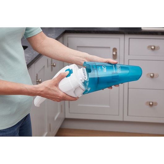 BLACKDECKER WDC115WA handheld vacuum with blue dust container in kitchen setting.