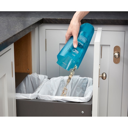 Photo of BLACKDECKER WDC115WA handheld vacuum being emptied into kitchen trash bins.